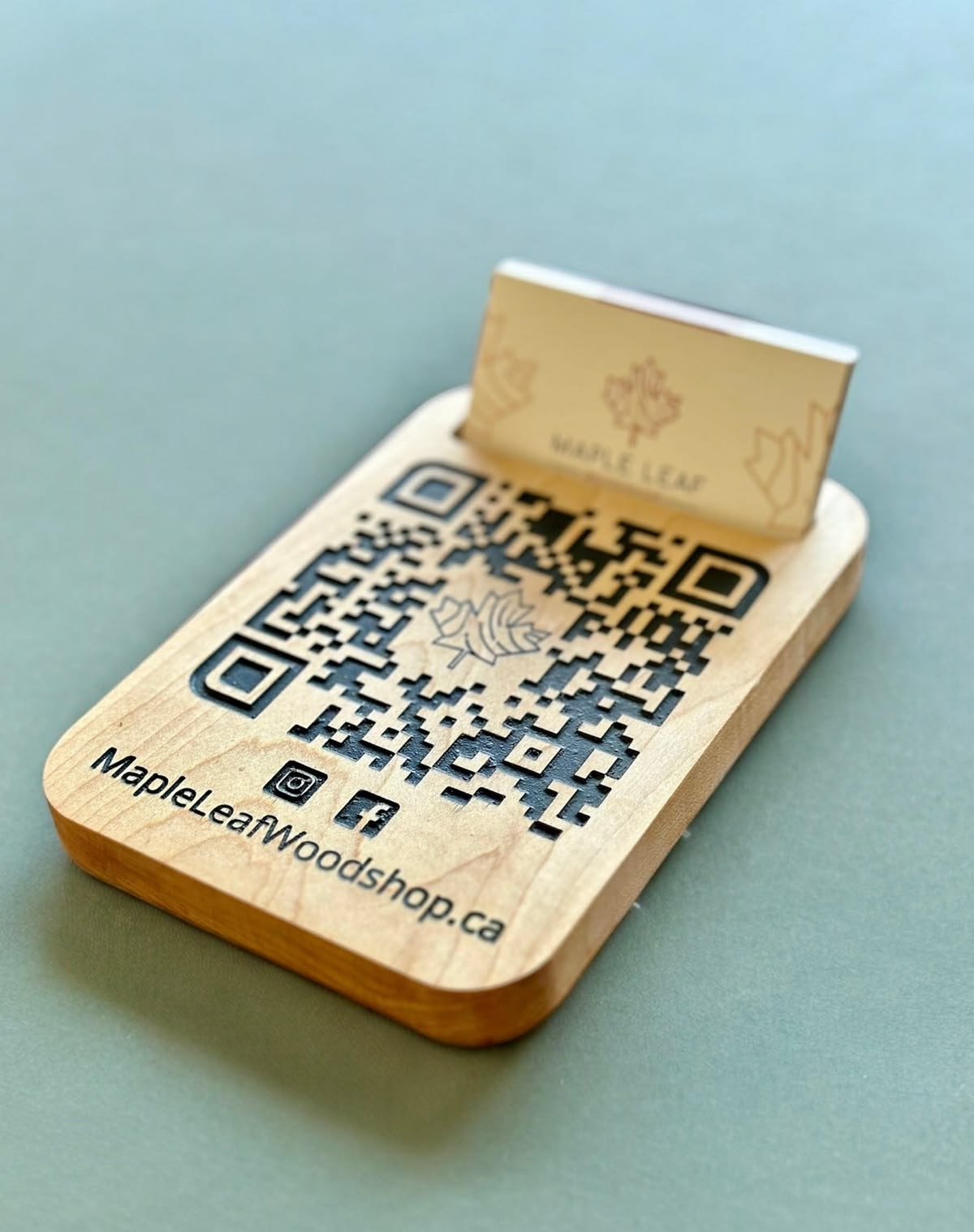 A wooden stand with an engraved QR code and a card holder